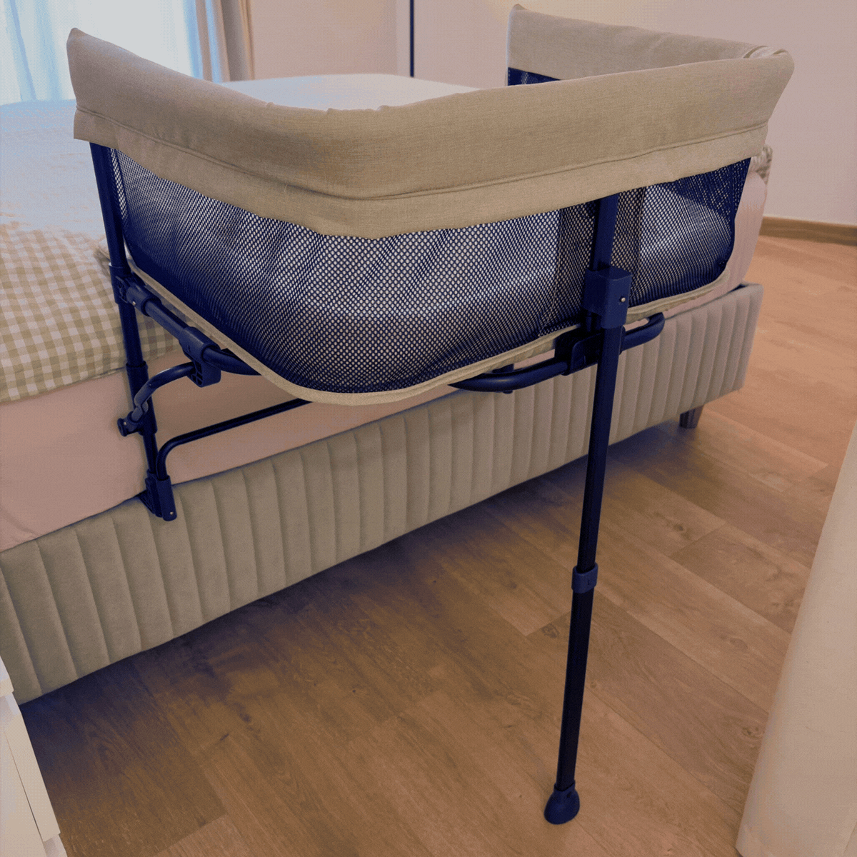 The bedside co-sleeper attaching to the human bed
